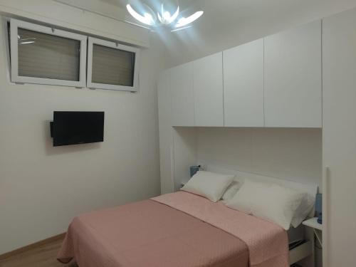 a bedroom with a bed and a tv on the wall at Casa Vacanze Lungomare in Piombino