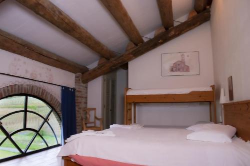 a bedroom with two beds and a window at Agriturismo Il Buonvicino in Cassine
