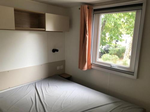 une chambre avec un lit et une fenêtre dans l'établissement Mobilhome 6 personnes Cap Ferret, à Lège-Cap-Ferret