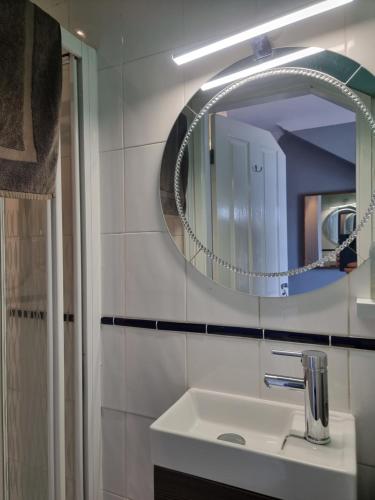 a bathroom with a sink and a mirror at The Hut Wales - A Sea Front Inn in Holyhead