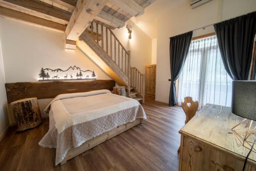 een slaapkamer met een bed en een houten vloer bij Agriturismo La Dolza in Follina