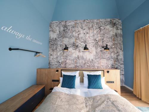 een slaapkamer met een groot bed met blauwe muren bij Seebrücke Heringsdorf - Appartement mit 2 Schlafzimmern und Terrasse S17 in Heringsdorf