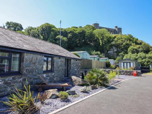 a stone house with a bench in front of it at Tan Llech in Harlech