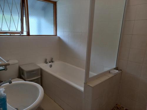 uma casa de banho com uma banheira e um lavatório em Our holiday home at the beach em Port Alfred
