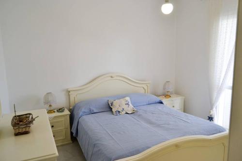 um quarto com uma cama com um cobertor azul e duas mesas de cabeceira em Casa Clarissa em Marina di Casalvelino