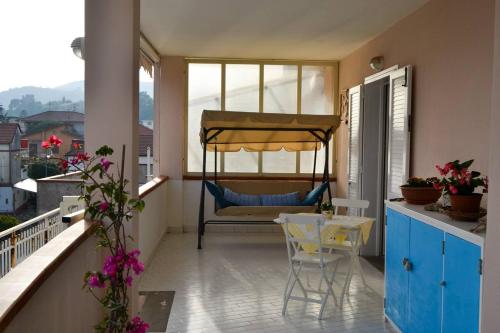 uma varanda com uma cama, uma mesa e cadeiras em Casa Clarissa em Marina di Casalvelino
