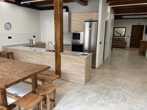 eine Küche mit Tisch und Edelstahlkühlschrank in der Unterkunft El Corazón de la Villa in Saldaña
