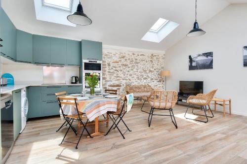 uma cozinha e sala de jantar com mesa e cadeiras em Detente dans une jolie maison a Noimoutier em Noirmoutier-en-l'lle