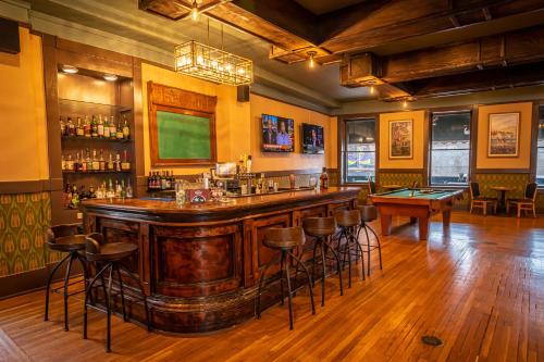 a bar in a pub with a table and stools at 1905 Basin Park Hotel in Eureka Springs