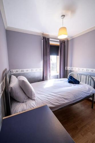 a bedroom with a bed and a window and a table at Seaside Home with Sea Views in Balmedie