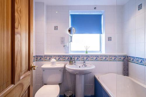 a bathroom with a toilet and a sink and a tub at Seaside Home with Sea Views in Balmedie