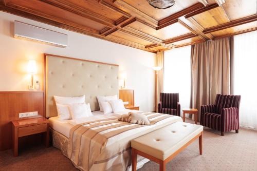 una habitación de hotel con una cama con un perro durmiendo en ella en Hotel Lindauer Hof, en Lindau