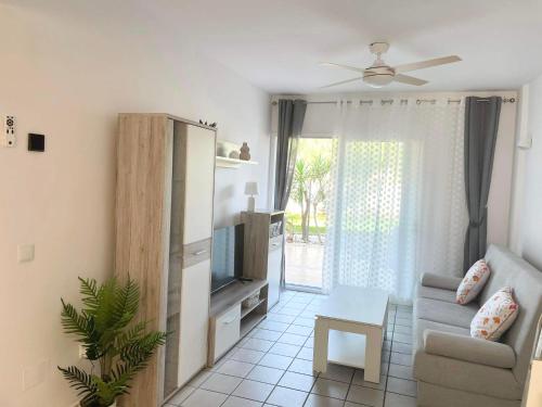 een woonkamer met een bank en een televisie bij Casa Monet - La Calma - 4 pools- Big terrace - Orihuela Costa in Playa Flamenca