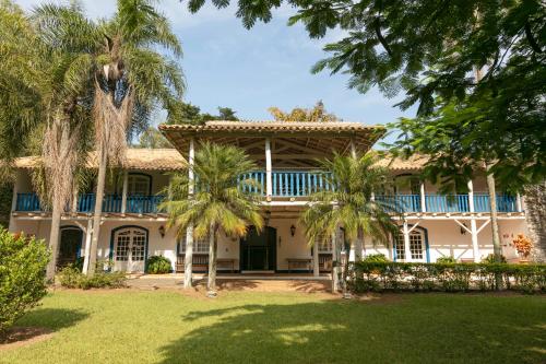 an exterior view of a house with palm trees at Fazenda Alvorada in Sorocaba