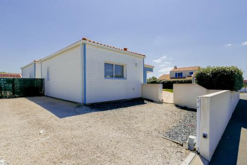 a small white building in a yard with a fence at Le Fenouiller - 6 personnes, Maison Piscine in Le Fenouiller