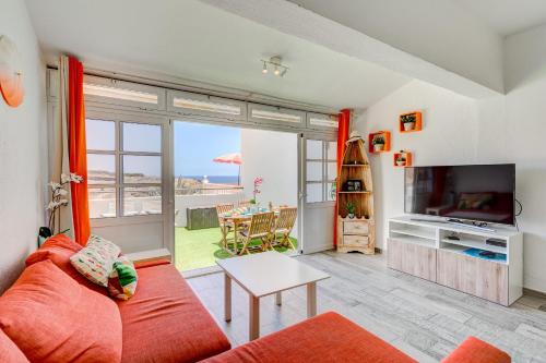 a living room with a red couch and a television at Aguaviva FREE WIFI by Olax Rentals in Callao Salvaje