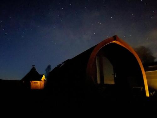 a tent is lit up at night in the dark at Cedar Cabin in Hexham