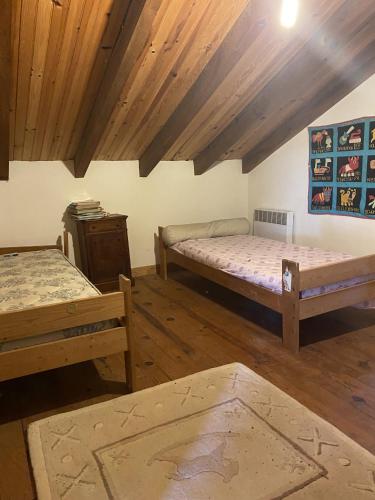 Habitación con 2 camas y techo de madera. en Buvolaccia, 