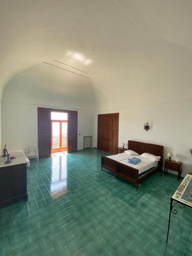 a large room with two beds and a green floor at Casa di don Francesco in Scala
