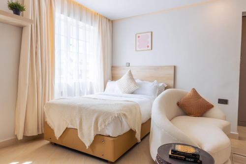 sypialnia z łóżkiem i krzesłem w obiekcie Luxe Studio and 1 bedroom Apartment w mieście Naivasha