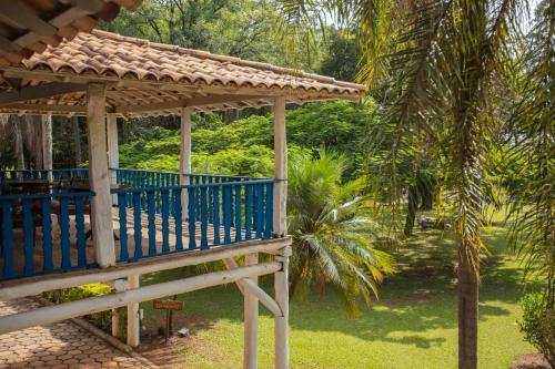 un kiosque en bois dans un jardin avec un palmier dans l'établissement Fazenda Alvorada, à Sorocaba