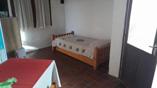 um pequeno quarto com uma cama e uma mesa em I Casa de invitados cerquita de la playa buenas olas em La Aguada