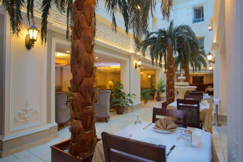 a restaurant with a table and chairs and palm trees at Emporium Hotel in Istanbul