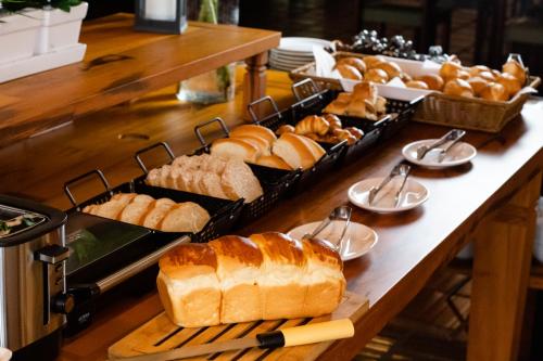 um buffet de pão e produtos de pastelaria numa mesa em Vale Das Águas Fazenda Resort em Águas de Santa Barbara