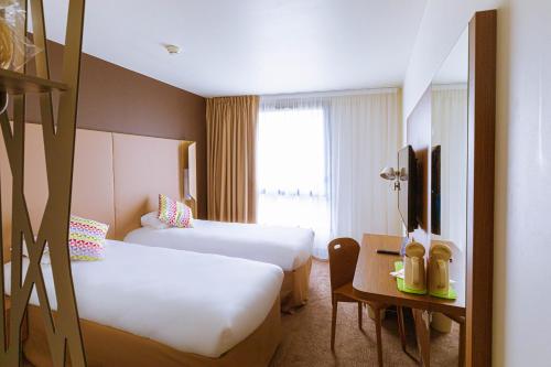 Pokój hotelowy z 2 łóżkami i biurkiem w obiekcie Campanile Rungis - Orly w mieście Chevilly-Larue