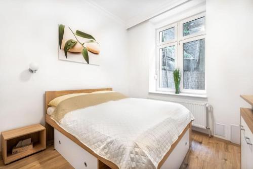 ein weißes Schlafzimmer mit einem Bett und einem Fenster in der Unterkunft Apartment HOT SPRING in Karlsbad