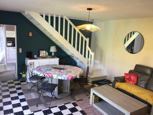 un salon avec une table et un escalier dans l'établissement au calme à Etretat, à Étretat