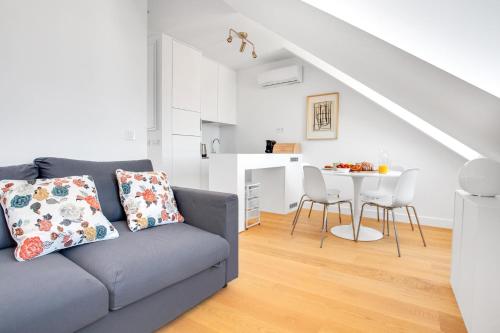 uma sala de estar com um sofá e uma mesa em Brand New River View Apartment Belém - 1 bedroom, A/C em Lisboa