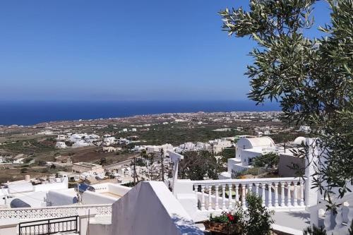 vistas a una ciudad con edificios blancos y al océano en v&n villa santorini, en Fira