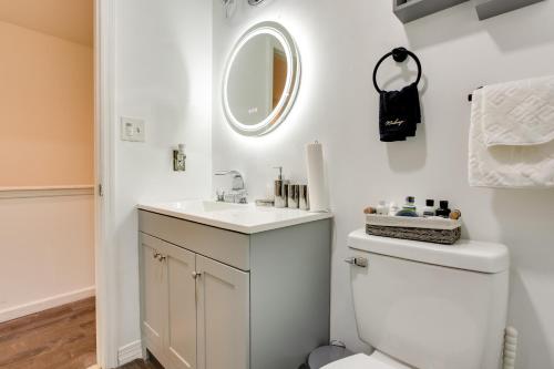 a bathroom with a toilet and a sink and a mirror at Modern Newark Vacation Rental Near Downtown! in Newark