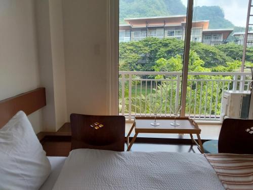 a bedroom with a bed and a view of a balcony at Seanna's Place at Pico de Loro in Nasugbu