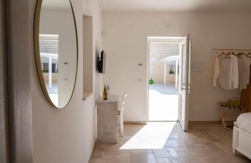 Dieses weiße Zimmer verfügt über einen Spiegel und einen Flur. in der Unterkunft Masseria Spiga in Gravina in Puglia