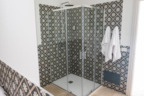 a shower in a bathroom with a tile wall at Masseria Spiga in Gravina in Puglia