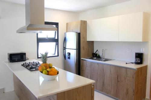 a kitchen with a bowl of fruit on a counter at Amar'e Aparthotel & Spa in Las Terrenas