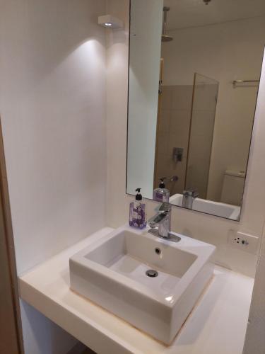 a bathroom with a white sink and a mirror at Seanna's Place at Pico de Loro in Nasugbu