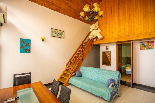 a living room with a staircase and a couch at Kaprovani Sand in Ureki
