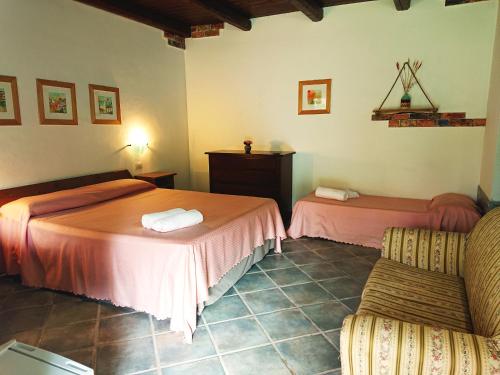 a room with two beds and a chair in it at Agriturismo Desole in Monti
