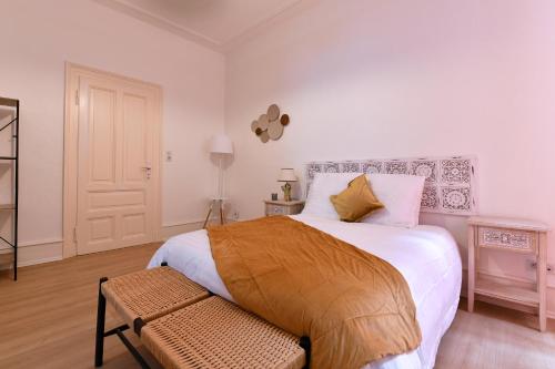 a bedroom with a large bed and a chair at At Home in Colmar - City center in Colmar