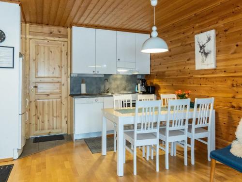レヴィにあるHoliday Home Levin kalle a3 by Interhomeの白いキャビネット、テーブルと椅子付きのキッチンが備わります。