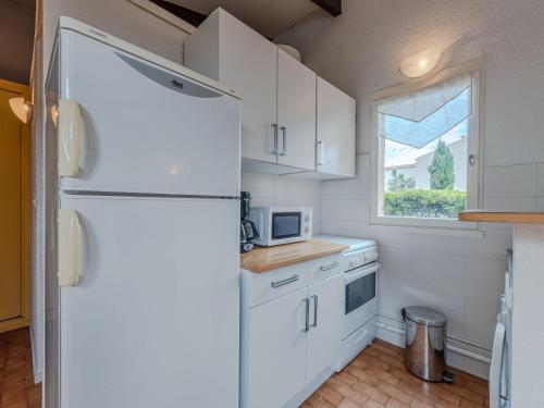 uma cozinha com um frigorífico branco e uma janela em Holiday Home Le Hameau des Capellans by Interhome em Saint-Cyprien-Plage