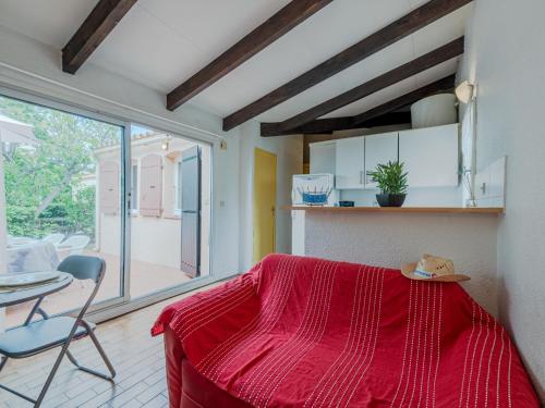a kitchen with a red blanket on a table at Holiday Home Le Hameau des Capellans by Interhome in Saint-Cyprien-Plage