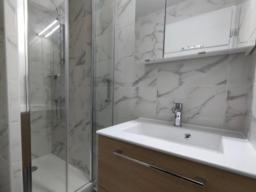 une salle de bain avec un lavabo et une douche avec un miroir dans l'établissement Apartment Les Mas de La Mer-1 by Interhome, à Saint Cyprien Plage