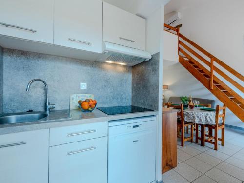 eine Küche mit weißen Schränken und ein Esszimmer in der Unterkunft Holiday Home Le Clos de St Cyprien by Interhome in Saint Cyprien Plage