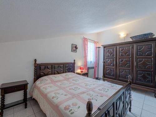 Schlafzimmer mit einem großen Bett mit einem Kopfteil aus Holz in der Unterkunft Holiday Home Le Clos de St Cyprien by Interhome in Saint Cyprien Plage
