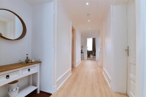 a hallway with white walls and a mirror on the wall at At Home in Colmar - City center in Colmar