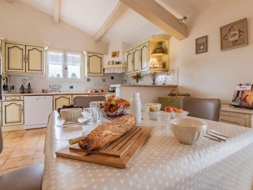 a kitchen with a table with a loaf of bread on a cutting board at Holiday Home Les Iris by Interhome in Gargas